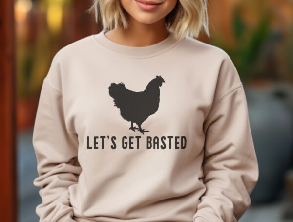 Sand color shirt with a black silhouette of a rooster and words that say Let's get Basted